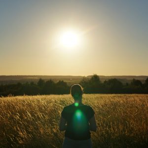 Psysoulogy photograph of a woman standing in the sunshine in front of a field